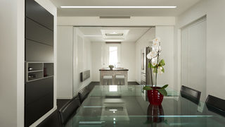 Sala da pranzo con tavolo in vetro e sedie nere. Ristrutturazione Eur Roma. (Progetto Contrasti)